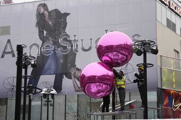 FILE - Workers install decorations ahead of the Christmas festival at a mall in Beijing on Dec. 14, 2023. A survey of factory managers in China shows manufacturing contracted in December in the latest sign the world’s No. 2 economy is still sluggish. (AP Photo/Ng Han Guan, File)