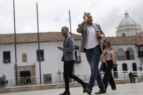 Mayor-elect Mikhail Krasnov waves to a supporter as he walks through Bolivar Square in Tunja, Colombia, Monday, Dec. 11, 2023. Krasnov, a 45-year-old university professor from Russia, was one of the unexpected winners in Colombia’s regional elections in October. (AP Photo/Fernando Vergara)