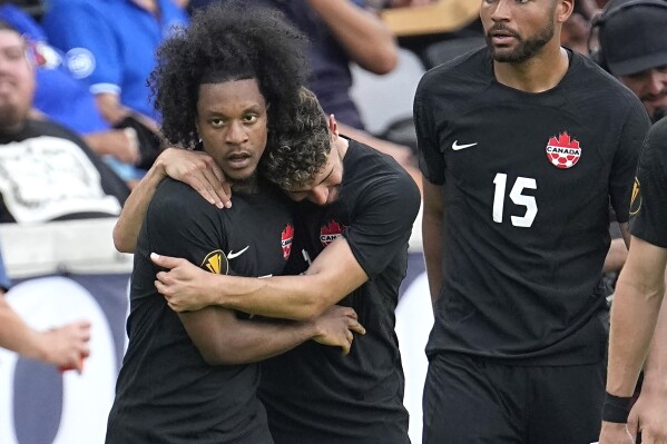 Canada's Jayden Nelson, left, celebrates with Jonathan Osorio, center, after scoring a goal against Cuba during the second half of a CONCACAF Gold Cup soccer match Tuesday, July 4, 2023, in Houston. (AP Photo/David J. Phillip)