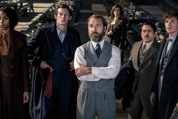 This image released by Warner Bros. Pictures shows, from left, Jessica Williams, Callum Turner, Jude Law, Fionna Glascott, Dan Fogler and Eddie Redmayne in a scene from "Fantastic Beasts: The Secrets of Dumbledore." (Warner Bros. Pictures via AP)
