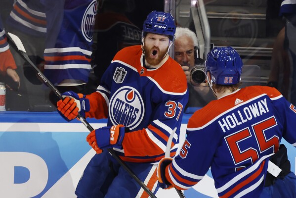 Edmonton Oilers' Warren Foegele (37) celebrates his goal against the Florida Panthers with Dylan Holloway (55) during the first period of Game 6 of the NHL hockey Stanley Cup Final, Friday, June 21, 2024, in Edmonton, Alberta. (Jeff McIntosh/The Canadian Press via AP)