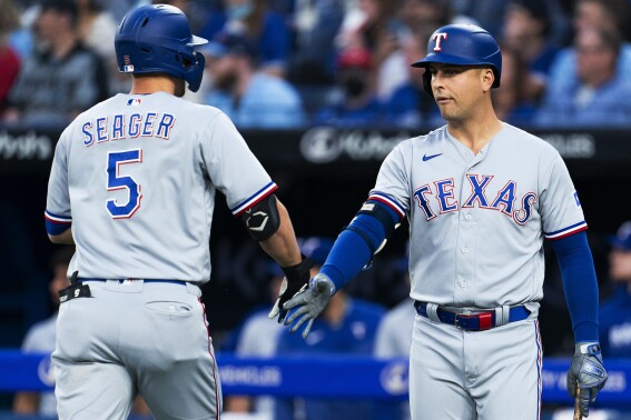 Texas Rangers' Corey Seager celebrates his solo home run against the Toronto Blue Jays with Nathaniel Lowe during the first inning of a baseball game Thursday, Sept. 14, 2023, in Toronto. (Spencer Colby/The Canadian Press via AP)