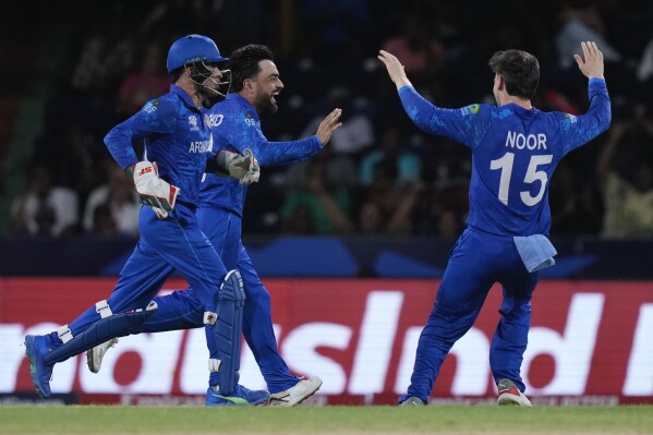 Afghanistan's captain Rashid Khan, centre, celebrates the wicket of Australia's Matthew Wade during the men's T20 World Cup cricket match between Afghanistan and Australia at Arnos Vale Ground, Kingstown, Saint Vincent and the Grenadines, Saturday, June 22, 2024. (AP Photo/Ramon Espinosa)