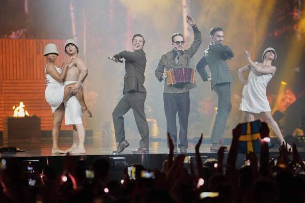 KAJ from Sweden performs the song "Bara Bada Bastu" during the first semi-final of the 69th Eurovision Song Contest, in Basel, Switzerland, Tuesday, May 13, 2025. (AP Photo/Martin Meissner)