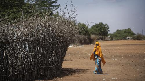 FILE - A Somali refugee girl walks past the fence surrounding a hut at Dadaab refugee camp, then hosting over 230,000 inhabitants, in northern Kenya on Dec. 19, 2017. Hundreds of refugees in Kenya's Dadaab camps have been affected by a cholera outbreak as the population in the facilities grows rapidly, a humanitarian charity said Tuesday, May 30, 2023. (AP Photo/Ben Curtis, File)