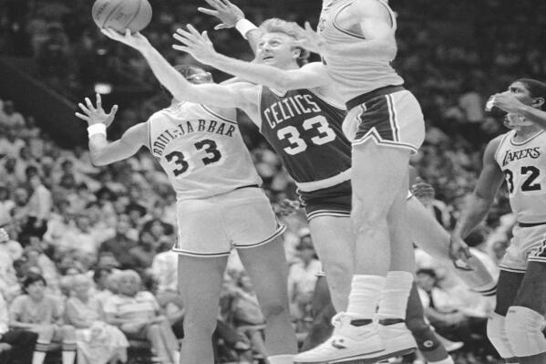 FILE - Boston Celtics forward Larry Bird (33) attempts a shot through defending Los Angeles Lakers forward Kurt Rambis (31), right and center Kareem Abdul Jabbar during NBA Championship series match on June 8, 1985, at the Forum in Inglewood, Calif. (AP Photo/Lennox McLendon)