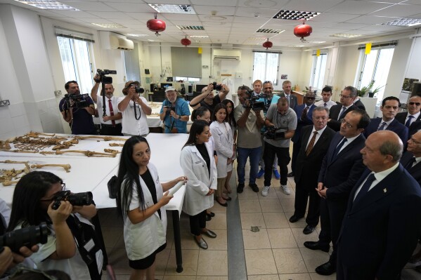 Cyprus' President Nikos Christodoulides, second right, and Turkish Cypriot leader Ersin Tatar, right, visit the anthropological laboratory of the Committee on Missing Persons, a UN facilitated body tasked with uncovering the fate of Greek and Turkish Cypriots who disappeared during inter communal fighting in the 1960s and a 1974 Turkish invasion that ethnically split the island nation, at a United Nations compound inside the U.N buffer zone in the divided capital Nicosia, Cyprus, Friday, July 28, 2023. The two leaders appealed to those with any information leading to the discovery of remains of the missing to step forward, especially as many are now passing away. (AP Photo/Petros Karadjias)