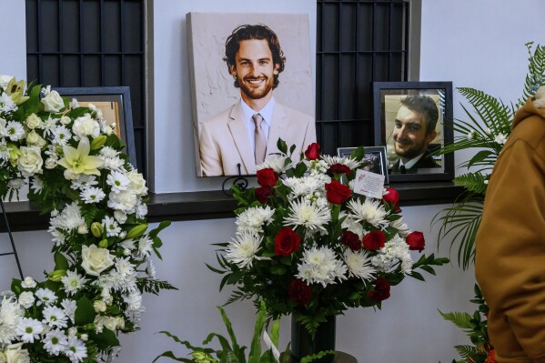 Photos of Adam Johnson line the ticket window booth at the Hibbing Memorial Building, in Hibbing, Minn., Monday, Nov. 6, 2023, as part of a celebration of life ceremony for the hockey player and Hibbing native who was killed in a hockey accident on Oct. 28 while playing in England. (Mark Sauer /The Mesabi Daily News via AP)