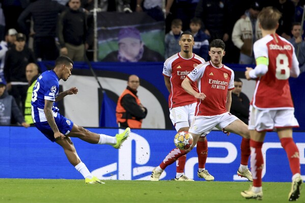 Porto's Galeno, left, scores the opening goal during a Champions League round of 16 soccer match between FC Porto and Arsenal at the Dragao stadium in Porto, Portugal, Wednesday, Feb. 21, 2024. (AP Photo/Luis Vieira)