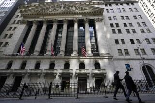 FILE - In this March 23, 2021 file photo, pedestrians walk past the New York Stock Exchange in New York's Financial District. Stocks are pulling back in the early going on Wall Street, easing the S&P 500 below the record high it set a day earlier. The index is still on track to close out its third solid monthly gain in a row. It was down 0.5% in the first few minutes of trading Friday, April 30, and technology and communications stocks were doing the most damage. (AP Photo/Mary Altaffer, File)
