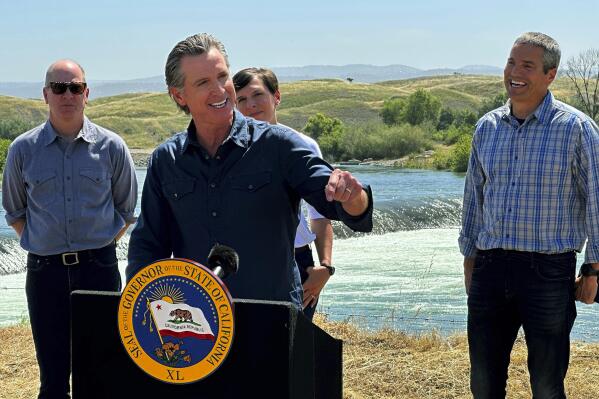 California Gov. Gavin Newsom speaks during a news conference in front of the Daguerre Point Dam on Tuesday, May 16, 2023, in Marysville, Calif. Local, state and federal officials plan to build a channel around the dam so threatened species of fish can access more habitat. (AP Photo/Adam Beam)