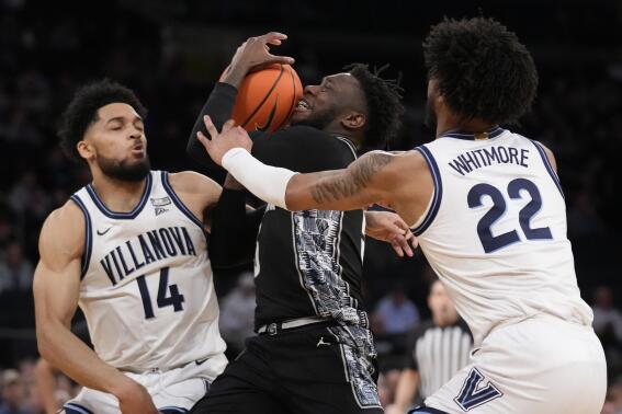 Georgetown's Jay Heath (5) drives against Villanova's Caleb Daniels (14) and Cam Whitmore (22) in the second half of an NCAA college basketball game during the first round of the Big East conference tournament, Wednesday, March 8, 2023, in New York. (AP Photo/John Minchillo)