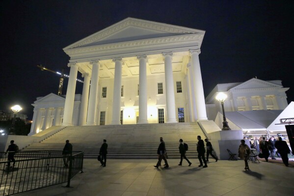 House of Delegates members walk past the south portico at the Virginia State Capitol in Richmond, Va., Wednesday, April 22, 2020. (Bob Brown/Richmond Times-Dispatch via AP, Pool, File)