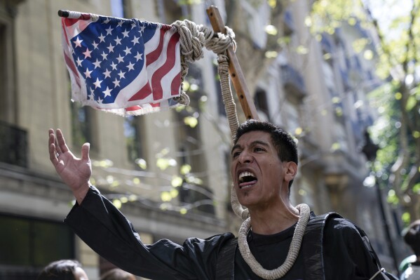 A demonstrator wears a U.S. flag motif noose during a march to Congress as part of a national strike to protest economic and labor reforms proposed by Argentine President Javier Milei in Buenos Aires, Argentina, Wednesday, Jan. 24, 2024. (AP Photo/Rodrigo Abd)