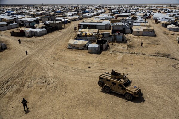 FILE - Kurdish forces patrol al-Hol camp, which houses families of members of the Islamic State group in Hasakeh province, Syria, on April 19, 2023. The U.S.-backed force that defeated the Islamic State group in Syria five years ago warned Saturday, March 23, 2024, that the extremists still pose grave dangers throughout the world and called on the international community to find solutions for thousands of fighters still held in its jails. (AP Photo/Baderkhan Ahmad, File)