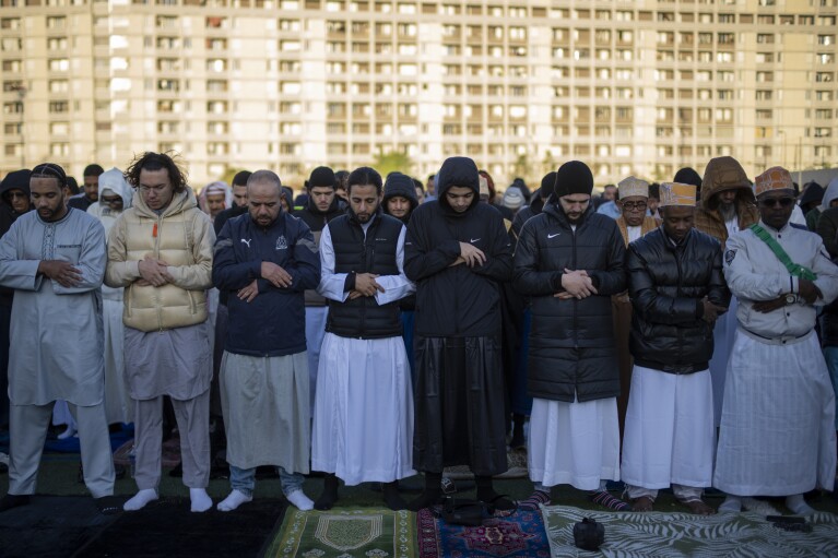 Muslim worshippers offer Eid al-Fitr prayers marking the end of the holy fasting month of Ramadan at the Malpasse soccer stadium in Marseille, southern France, Wednesday, April 10, 2024. (AP Photo/Daniel Cole)