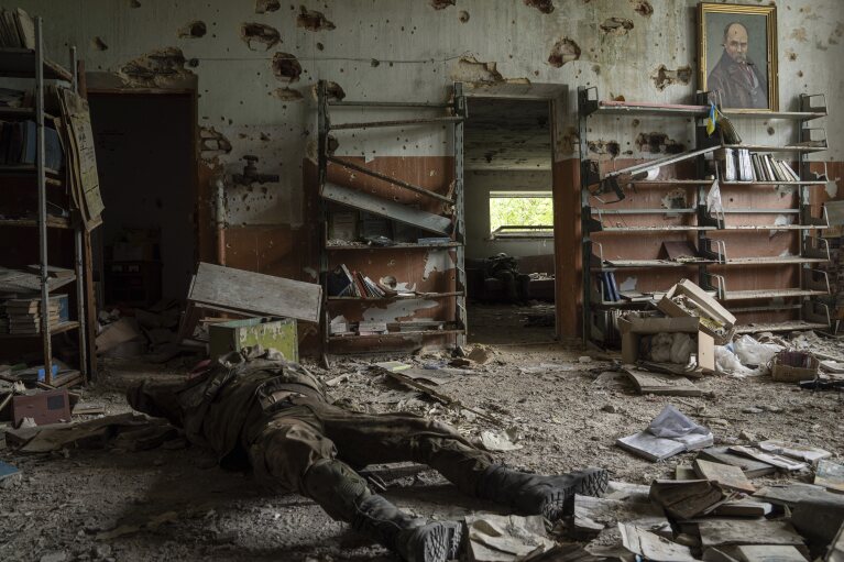 FILE - The body of a Russian soldier lies inside a building in the village of Blahodatne, Ukraine, Saturday, June 17, 2023. (AP Photo/Evgeniy Maloletka, File)