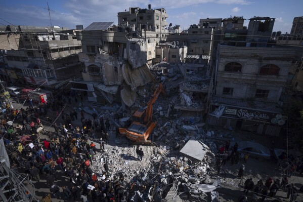 FILE - Palestinians search for bodies and survivors in the rubble of a residential building destroyed in an Israeli airstrike in Rafah, Gaza Strip, Monday, March 4, 2024. Israel can either try to annihilate Hamas, which would mean almost certain death for the estimated 100 hostages still held in Gaza, or it can cut a deal that would allow the militants to claim a historic victory. Either outcome would be excruciating for Israelis. And either might be seen as acceptable by Hamas, which valorizes martyrdom. (AP Photo/Fatima Shbair)
