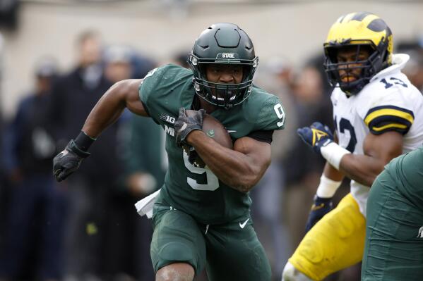 Michigan State's Kenneth Walker III (9) rushes against Michigan's Josh Ross during the first quarter of an NCAA college football game, Saturday, Oct. 30, 2021, in East Lansing, Mich. Michigan State won 37-33. (AP Photo/Al Goldis)