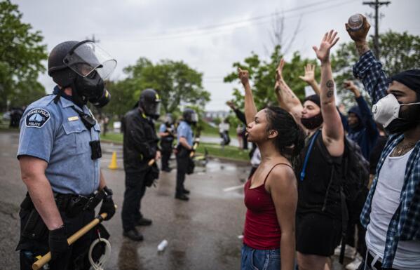 FILE - Protesters and police face each other during a rally for George Floyd in Minneapolis on May 26, 2020. Almost two years after George Floyd died at the hands of four Minneapolis police officers, Minnesota's Department of Human Rights was set Wednesday, April 27, 2022,  to announce findings from its investigation into whether the city police department had a pattern or practice of racial discrimination in policing. (Richard Tsong-Taatarii/Star Tribune via AP)