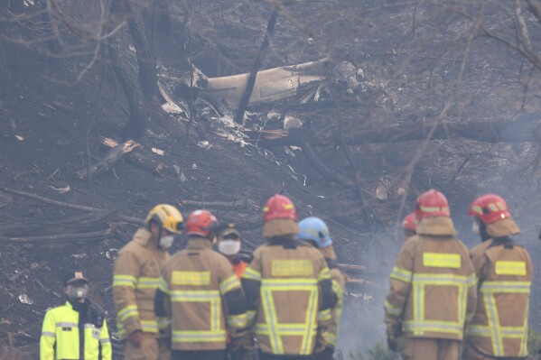 The wreckage of a crashed firefighting helicopter is seen at a mountain in Uiseong, South Korea, Wednesday, March 26, 2025. (Son Hyung-joo/Yonhap via AP)