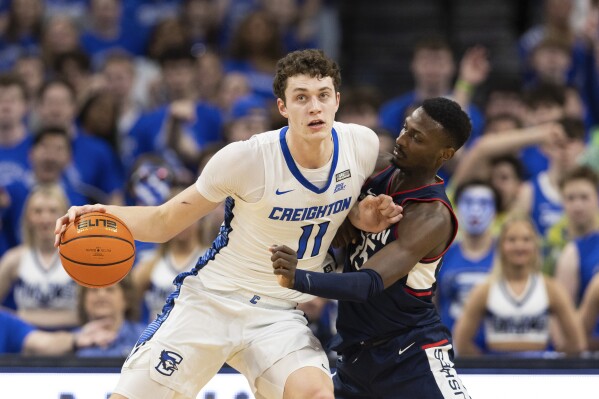 Creighton's Ryan Kalkbrenner, left, drives against UConn's Samson Johnson during the first half of an NCAA college basketball game Tuesday, Feb. 20, 2024, in Omaha, Neb. (AP Photo/Rebecca S. Gratz)