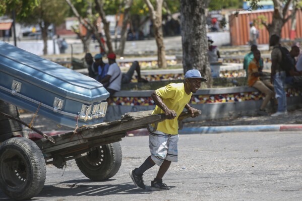 A man transports a coffin using a cart in Port-au-Prince, Haiti, Friday, March 22, 2024. (AP Photo/Odelyn Joseph)