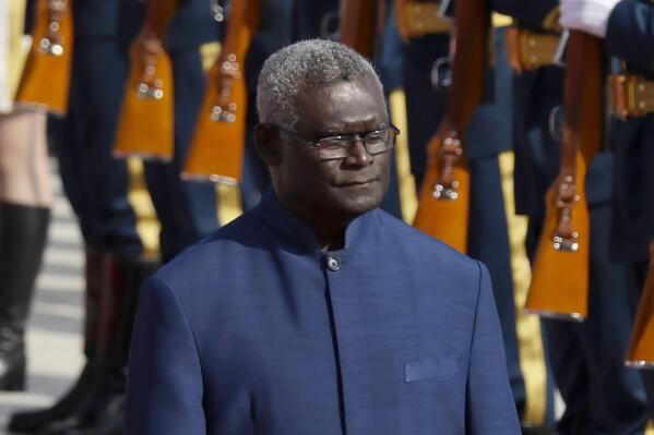 FILE - Solomon Islands Prime Minister Manasseh Sogavare reviews an honor guard during a welcome ceremony at the Great Hall of the People in Beijing, on Oct. 9, 2019. Sogavare said Thursday, July 14, 2022 that his country’s new security pact with Beijing would not allow China to build a military base on the South Pacific nation and make his citizens "targets for potential military strikes." (AP Photo/Mark Schiefelbein, File)