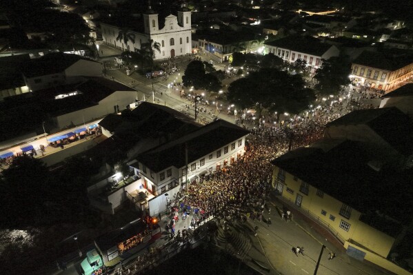 Revelers gather on a bridge during Carnival in Sao Luiz do Paraitinga, Brazil, Sunday, March 2, 2025. (AP Photo/Andre Penner)