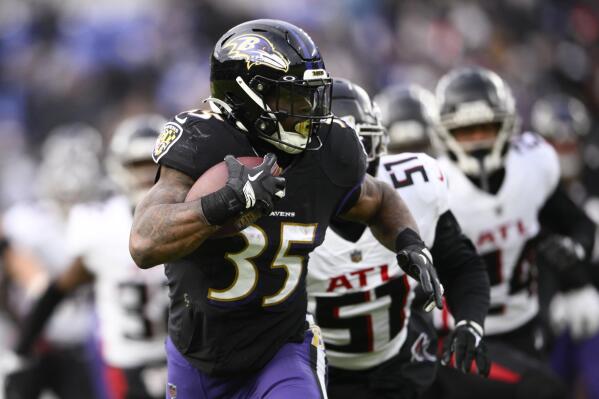 Baltimore Ravens running back Gus Edwards (35) carries past Atlanta Falcons linebacker DeAngelo Malone (51) during the second half of an NFL football game, Saturday, Dec. 24, 2022, in Baltimore. (AP Photo/Nick Wass)