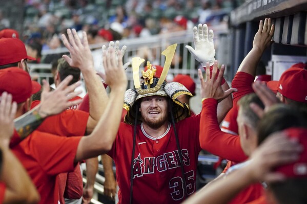 Los Angeles Angels catcher Chad Wallach (35) celebrates in the dugout after hitting a home run in the fifth inning of a baseball game against the Atlanta Braves, Monday, July 31, 2023, in Atlanta. (AP Photo/John Bazemore)