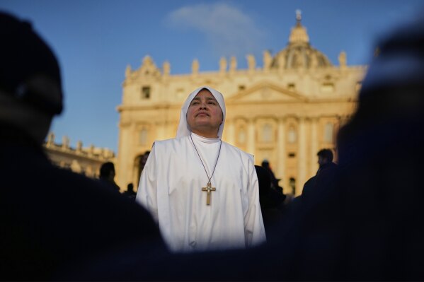 A nun waits in St. Peter's Square as people arrive ahead of the funeral of Pope Francis at the Vatican, Saturday, April 26, 2025. (AP Photo/Andreea Alexandru)