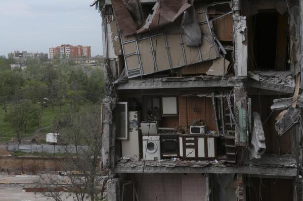 CORRECTS DAY - A part of an apartment is seen at the side of damaged during a heavy fighting buildings in Mariupol, in territory under the government of the Donetsk People's Republic, eastern Ukraine, Friday, May 13, 2022. (AP Photo)