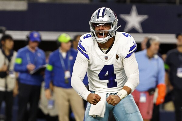 Dallas Cowboys quarterback Dak Prescott (4) celebrates after throwing a touchdown pass to Jake Ferguson, not pictured, in the second half of an NFL football game against the Seattle Seahawks in Arlington, Texas, Thursday, Nov. 30, 2023. (AP Photo/Roger Steinman)