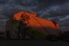 The setting sun illuminates a mural of a polar bear on the side of an apartment building, Sunday, Aug. 4, 2024, in Churchill, Manitoba. (AP Photo/Joshua A. Bickel)