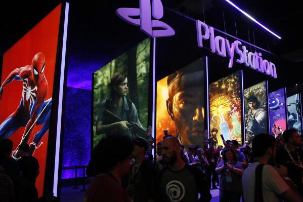 FILE - In this June 14, 2018 file photo people stand on a line next to the PlayStation booth at the Los Angeles Convention Center. PlayStation-maker Sony is escalating its competition with Xbox-maker Microsoft by buying the video game studio behind one of Xbox’s hit games. Sony Interactive Entertainment said Monday, Jan. 31, 2022 it would spend $3.6 billion to buy Bungie Inc., an independent game publisher based in Bellevue, Washington. (AP Photo/Damian Dovarganes, File)
