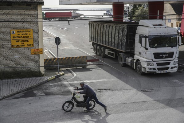 A truck exits from the port of Shengjin, northwestern Albania, on Tuesday, Nov. 7, 2023. Italian Premier Giorgia Meloni announced that Albania had agreed to give temporary shelter to thousands of migrants who try to reach Italian shores while their asylum bids are being processed. Albania will offer two facilities, a quarantine area at the port of Shengjin and an accommodation center for those who will be deported at a former military airport in Gjader. (AP Photo/Armando Babani)