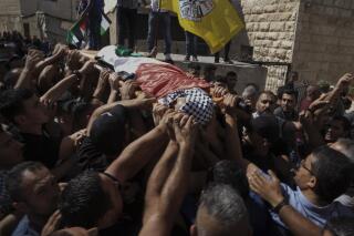 FILE - Mourners carry the body of 7-year-old Palestinian boy Rayan Suleiman during his funeral in the West Bank village of Tequa near Bethlehem Friday, Sept. 30, 2022. ​​The Israeli military on Thursday, Oct. 6,  cleared itself of wrongdoing in the death of a 7-year-old Palestinian boy whose family says he “died of fear” after an interaction with Israeli soldiers in the occupied West Bank. (AP Photo/Mahmoud Illean, File)