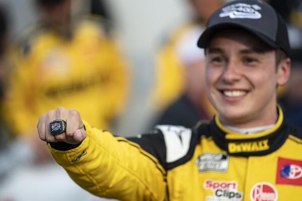 Christopher Bell holds out a ring he received for winning a NASCAR Cup Series auto race at Charlotte Motor Speedway, Sunday, Oct. 9, 2022, in Concord, N.C. (AP Photo/Matt Kelley)