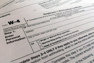 FILE - In this Feb. 5, 2020, file photo, a W-4 form is viewed in New York. The IRS will delay the traditional April 15 tax filing due date until May 17, 2021, to cope with added duties and provide Americans more flexibility. (AP Photo/Patrick Sison, File)