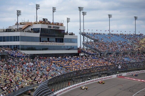 Scott McLaughlin, left, leads during an IndyCar auto race, Sunday, July 14, 2024, at Iowa Speedway in Newton, Iowa. (AP Photo/Charlie Neibergall)