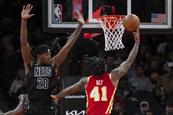 Atlanta Hawks forward Saddiq Bey (41) scores against Brooklyn Nets center Day'Ron Sharpe (20) during the first half of an NBA basketball game Wednesday, Nov. 22, 2023, in Atlanta. (AP Photo/Hakim Wright Sr.)