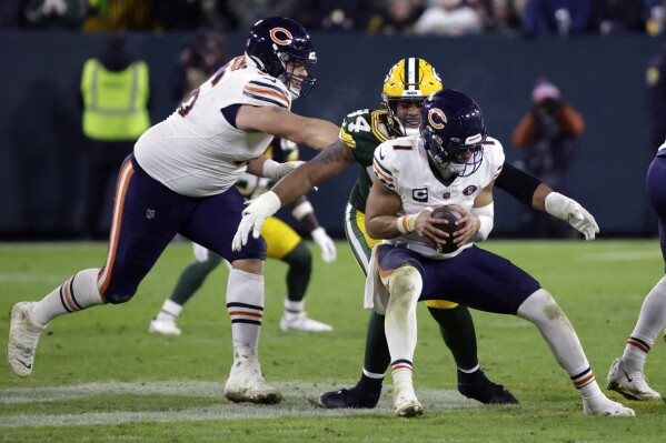 Chicago Bears quarterback Justin Fields is sacked by Green Bay Packers defensive end Karl Brooks (94) during the second half of an NFL football game Sunday, Jan. 7, 2024, in Green Bay, Wis. (AP Photo/Mike Roemer)