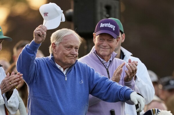Honorary Starter Jack Nicklaus acknowledges the patrons, as fellow Honorary Starter Tom Watson applauds, on the first hole during the first round at the Masters golf tournament, Thursday, April 10, 2025, in Augusta, Ga. (AP Photo/David J. Phillip)