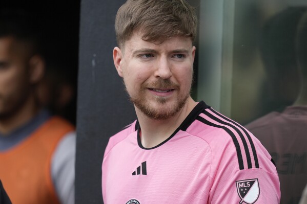 FILE - Jimmy Donaldson, the popular YouTube video maker who goes by MrBeast, wears a Lionel Messi jersey as he stands in a sideline box at the start of an MLS soccer match between Inter Miami and CF Montreal, March 10, 2024, in Fort Lauderdale, Fla. MrBeast is facing complaints about the safety of contestants from the preliminary rounds of his ambitious “Beast Games" game show, which boasts 1,000 competitors hoping for a $5 million grand prize. (AP Photo/Rebecca Blackwell, File)