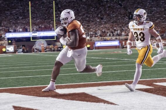 Texas defensive lineman Byron Murphy II, left, who was an eligible receiver, scores a touchdown against Wyoming defender Connor Shay during the first half of an NCAA college football game Saturday, Sept. 16, 2023, in Austin, Texas. (AP Photo/Michael Thomas)