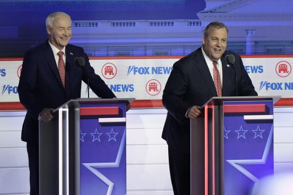 Former New Jersey Gov. Chris Christie smiles as he answers a question about UFO's as former Arkansas Gov. Asa Hutchinson listens during a Republican presidential primary debate hosted by FOX News Channel Wednesday, Aug. 23, 2023, in Milwaukee. (AP Photo/Morry Gash)