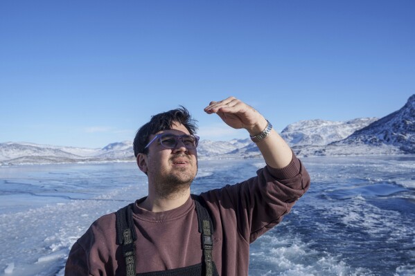 Cebastian Rosing, 35, rides on a boat at the sea ilnet near Kapisillit village in Greenland, March 6, 2025. (AP Photo/Evgeniy Maloletka)