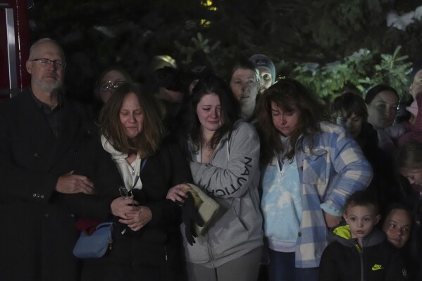 People gather at a candlelight vigil after two police officers and a first responder were shot and killed Sunday, Feb. 18, 2024, in Burnsville, Minn. (AP Photo/Abbie Parr)