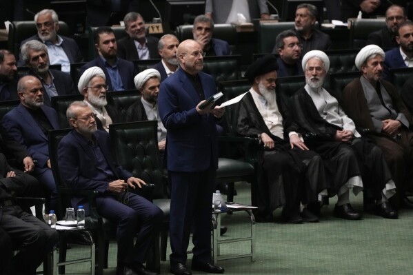 Mohammad Bagher Qalibaf, center, takes an oath during the opening ceremony of the new parliament term in Tehran, Iran, Monday, May 27, 2024. Iran's parliament re-elected hard-liner Qalibaf on Tuesday as its speaker, reaffirming its hard-right makeup in the wake of a helicopter crash that killed the country's president and foreign minister. (AP Photo/Vahid Salemi)